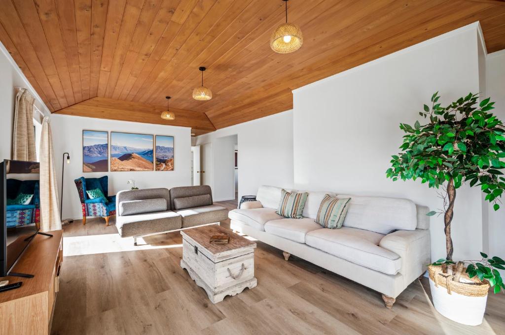 een woonkamer met een bank en een tv bij Family Perfect - Xmas bliss, secure yard, arcade in Rotorua