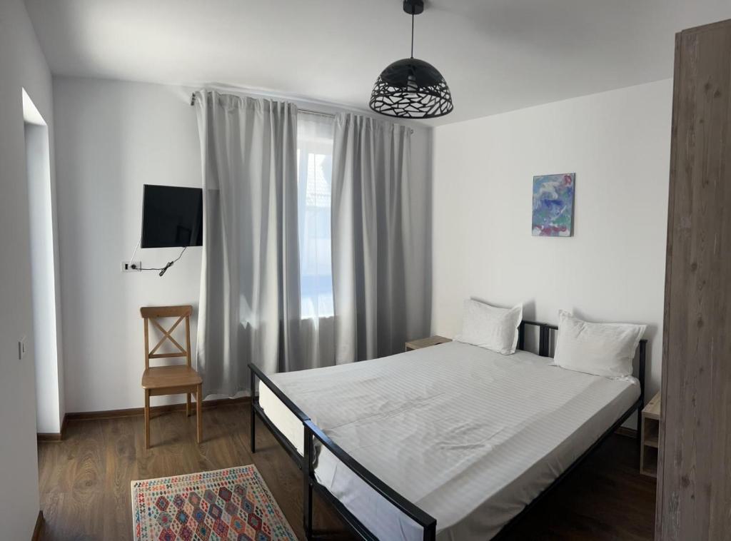 - une chambre avec un grand lit et une fenêtre dans l'établissement Vila Nova Residence, à Popeşti-Leordeni