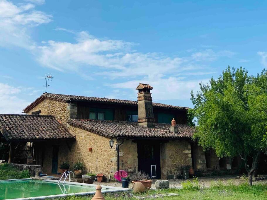 an old stone house with a pool in front of it at Finca Valdegrullas in Candeleda