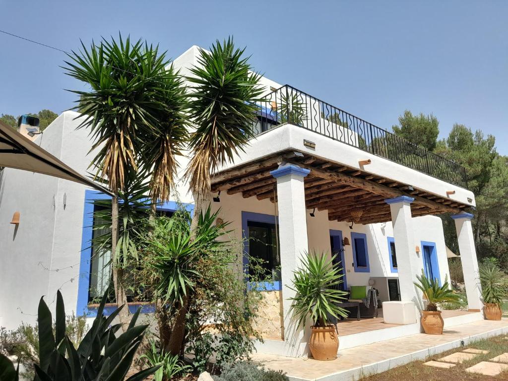 a house with palm trees in front of it at Sa Bardella in Sant Joan de Labritja