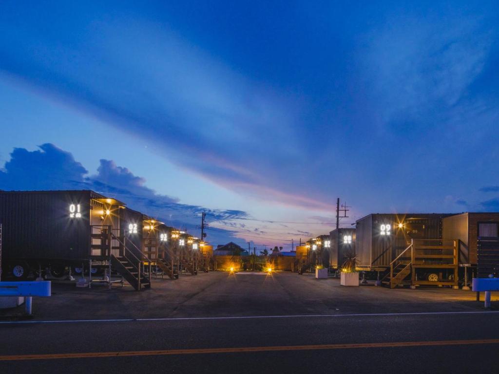 a parking lot with a row of trailers at night at Seage Torami Coastside in Ichinomiya