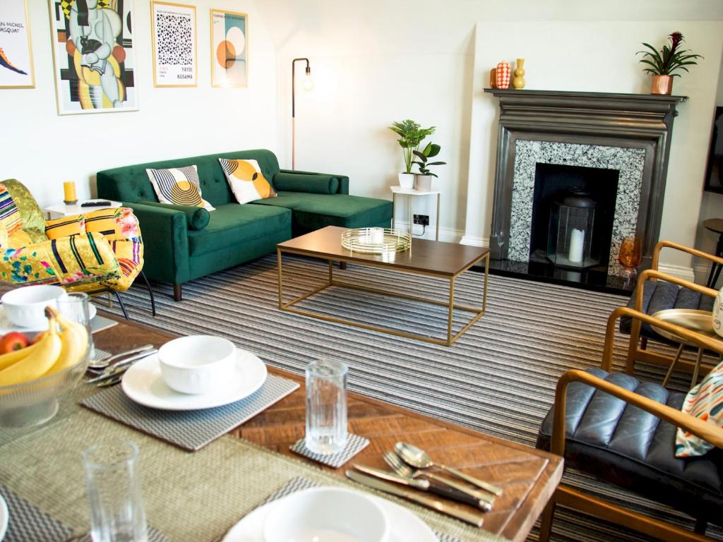 a living room with a green couch and a fireplace at Pass the Keys Stylish apartment in stunning location plus parking in Bath