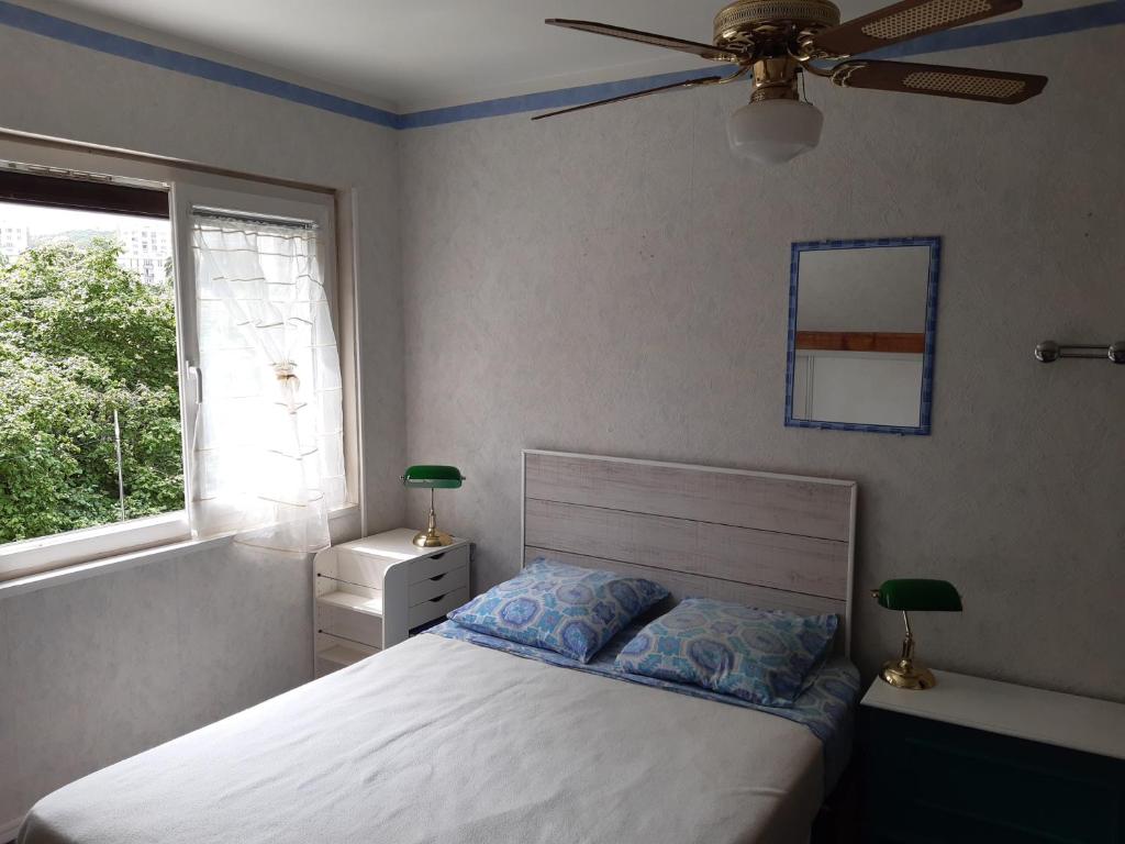 a bedroom with a bed and a ceiling fan at Le petit chemin in Bougival