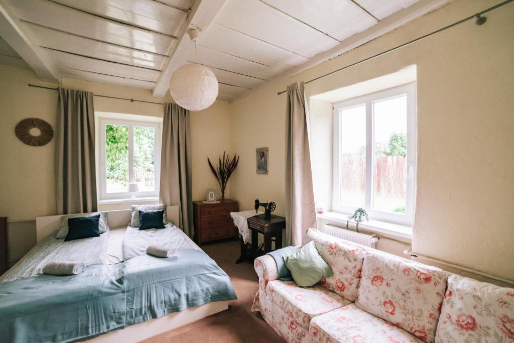 a bedroom with a bed and a couch and windows at SuperApart Sterławki Wielkie 31- Ideal for Relaxation & Escapes in Sterławki Wielkie