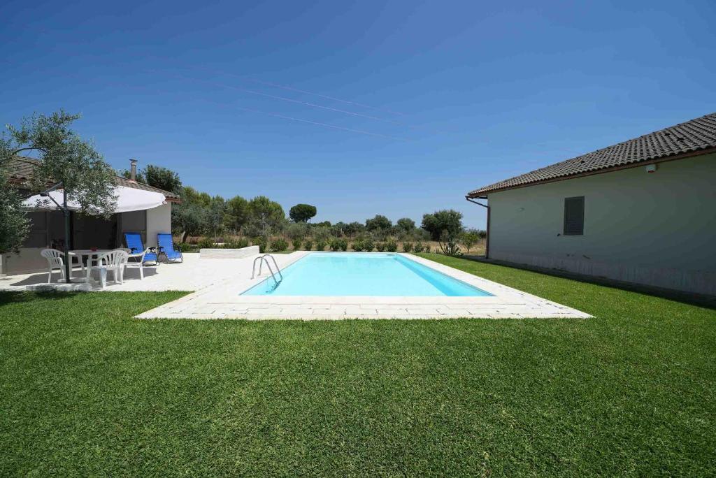 a swimming pool in a yard next to a house at Accogliente villa con piscina in Caltagirone