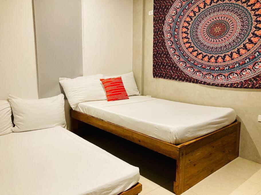 two beds in a room with a rug on the wall at Barkada Room 2 near Clark (Casa Isabela) in Mabalacat