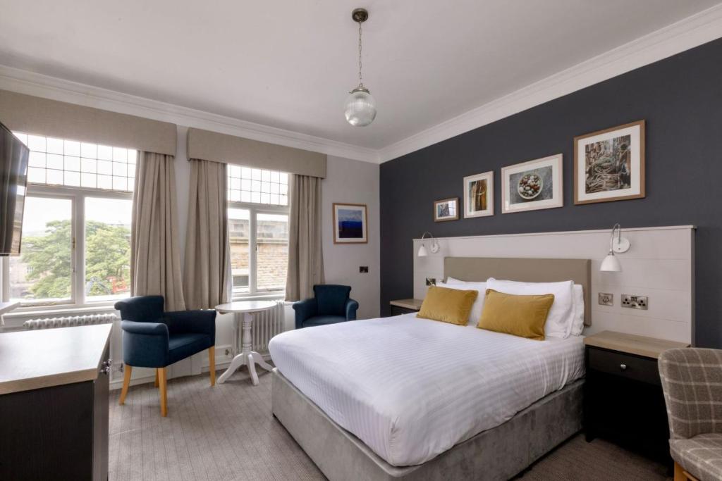 a hotel room with a bed and a desk and chairs at The Harrogate Inn - The Inn Collection Group in Harrogate