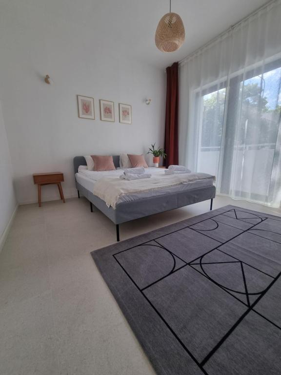 een slaapkamer met een bed en een groot raam bij Baltivia Haus I in Gdynia