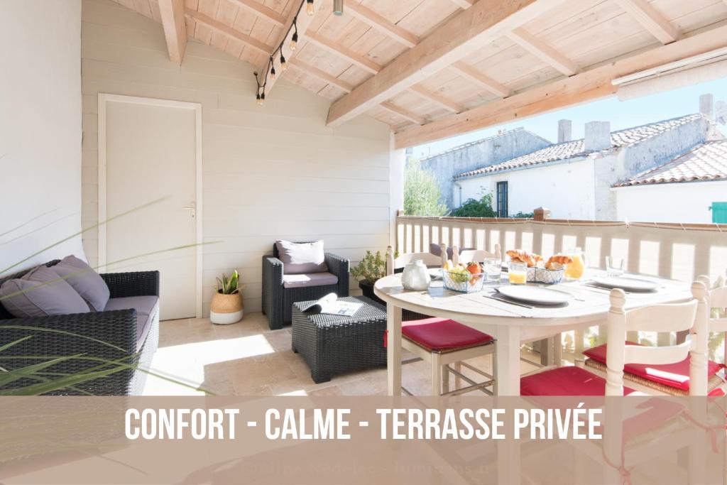 a patio with a table and chairs in a room at La Virginie - Suite Ile'Ô in La Couarde-sur-Mer