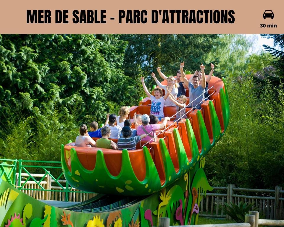 a group of people riding on a roller coaster ride at Le Cocon Forestier - Proche aéroport Beauvais, Chantilly, forêt de Hez-Froidmont, parking public gratuit, Wifi &amp; Netflix in Clermont