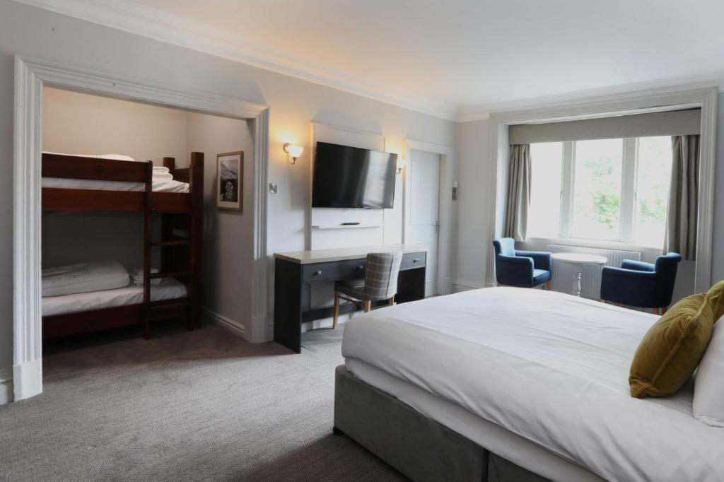 a hotel room with a bed and a desk with a television at The Harrogate Inn - The Inn Collection Group in Harrogate