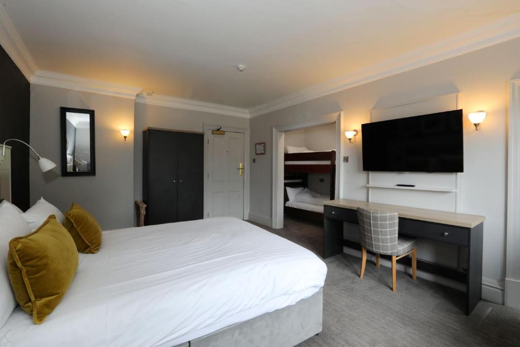 a hotel room with a bed and a desk and a television at The Harrogate Inn - The Inn Collection Group in Harrogate