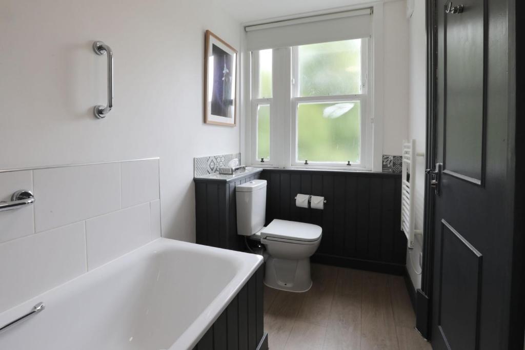 a bathroom with a toilet and a sink and a window at The Harrogate Inn - The Inn Collection Group in Harrogate