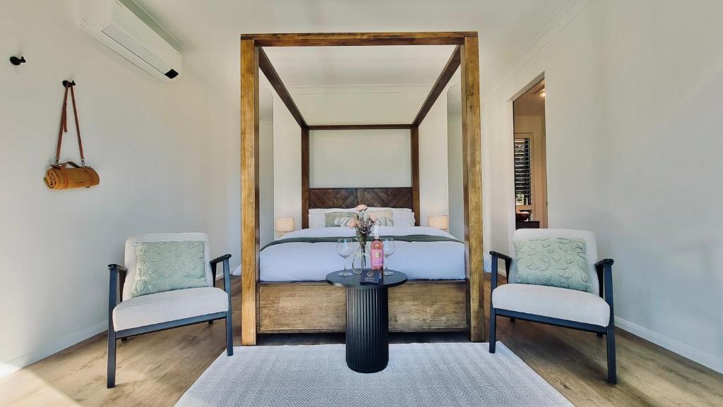 a bedroom with a bed with two chairs and a table at Ashiyana Escapes in Mount Tamborine