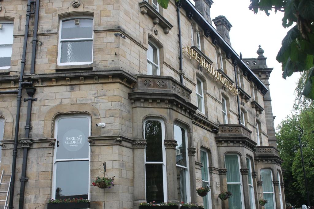 a large stone building with windows and a balcony at The Harrogate Inn - The Inn Collection Group in Harrogate