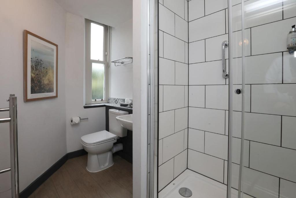 a white bathroom with a toilet and a shower at The Harrogate Inn - The Inn Collection Group in Harrogate