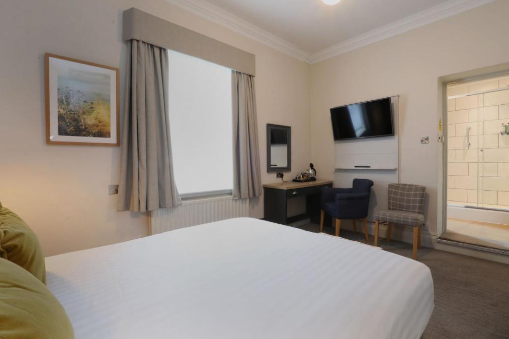 a hotel room with a bed and a desk and a television at The Harrogate Inn - The Inn Collection Group in Harrogate