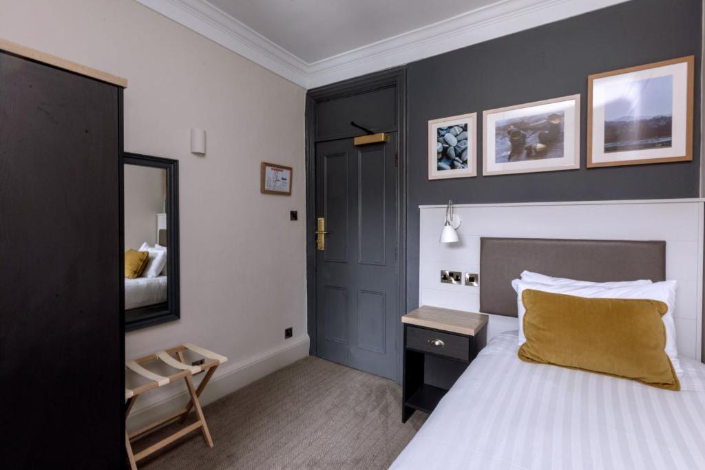 a bedroom with a bed and a table and a mirror at The Harrogate Inn - The Inn Collection Group in Harrogate