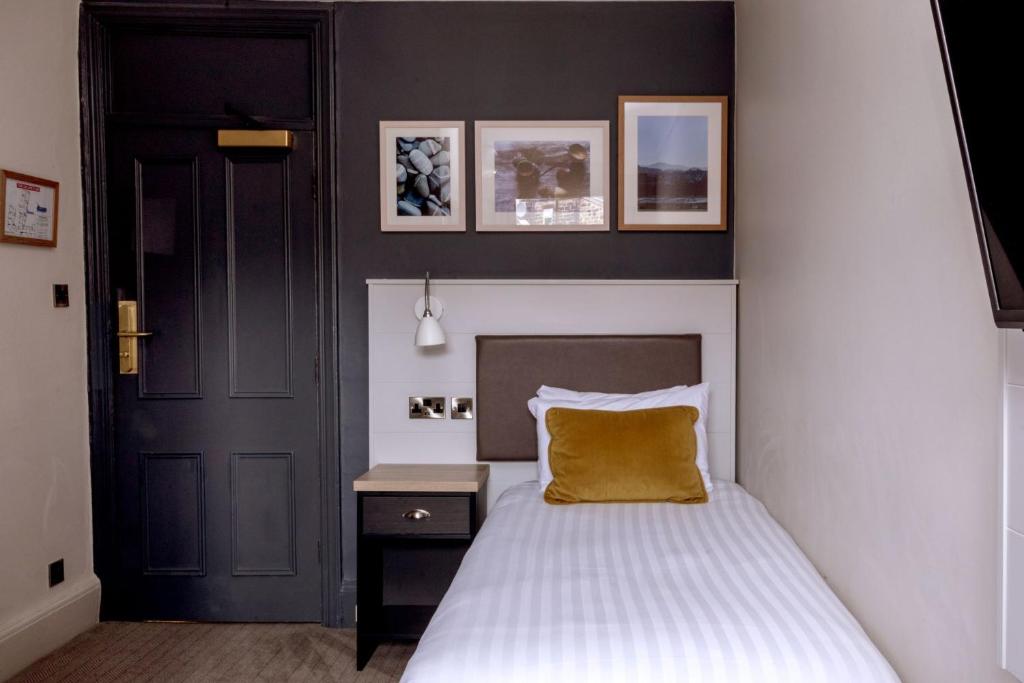 a bedroom with a bed with a yellow pillow at The Harrogate Inn - The Inn Collection Group in Harrogate
