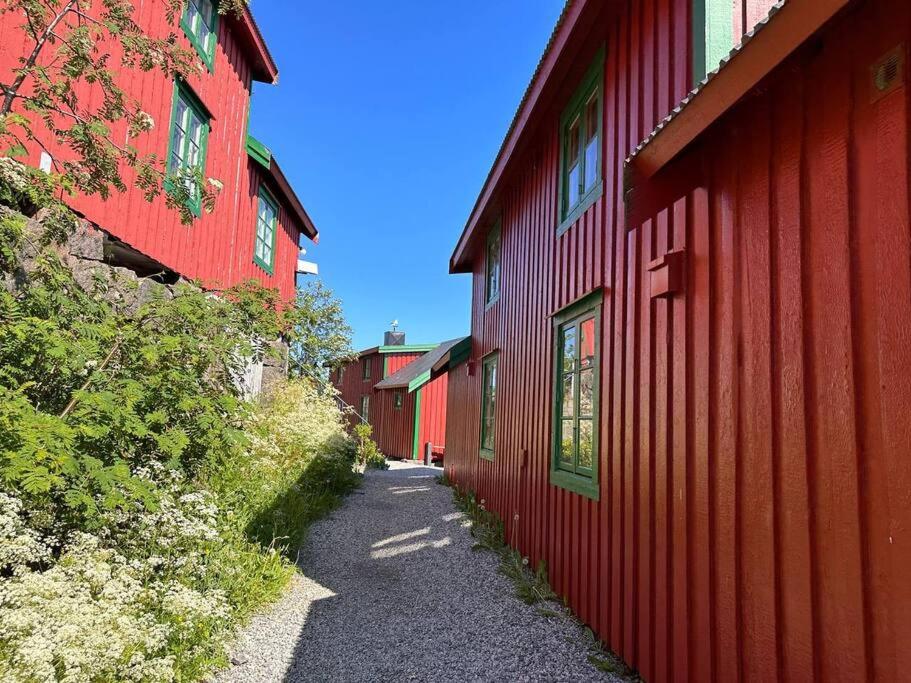 un sentiero tra due edifici rossi vicino a un edificio rosso di Stamsund Harbour Apartment a Stamsund