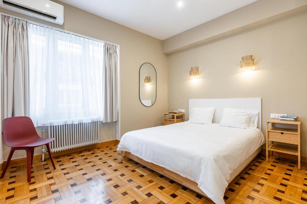 雅典的住宿－Kolonaki Suites by Olala Homes，卧室配有白色的床、椅子和窗户