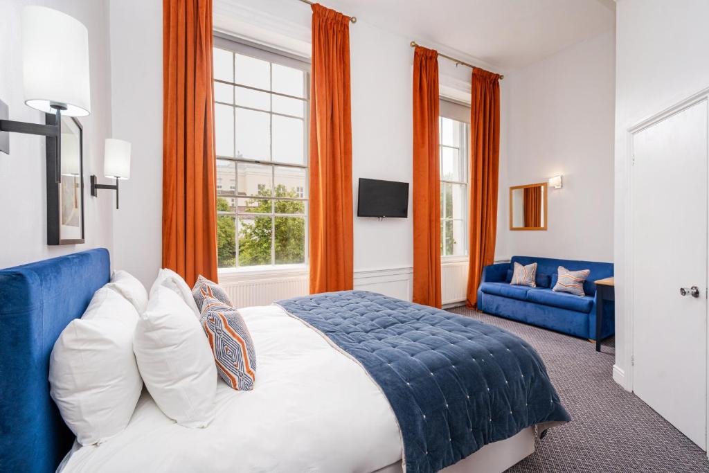 um quarto com uma cama grande e um sofá azul em The Rodney Hotel em Bristol