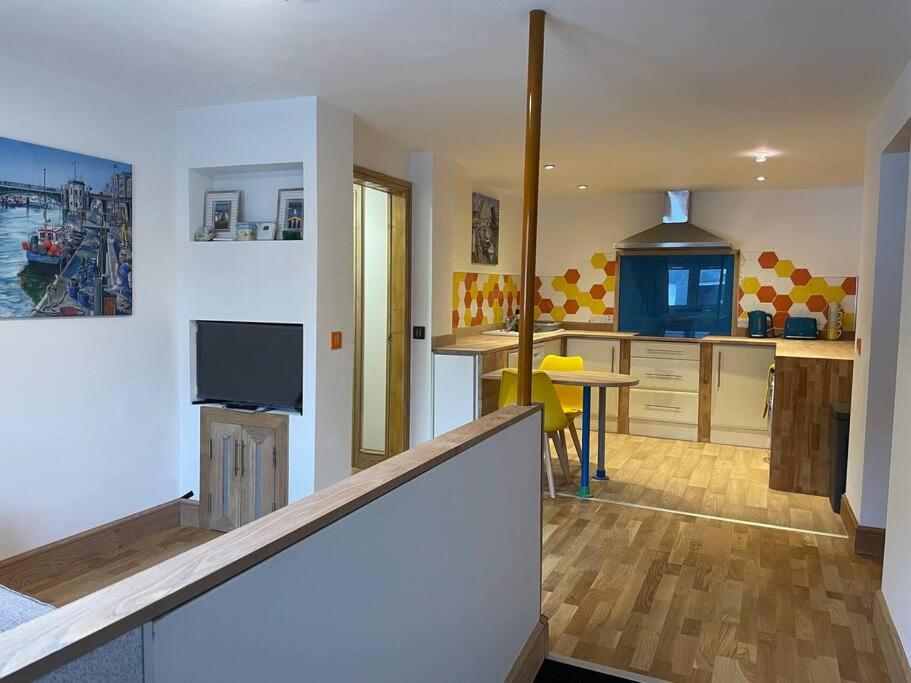 a room with a kitchen and a living room at Poshington willows accessibility friendly in Weymouth