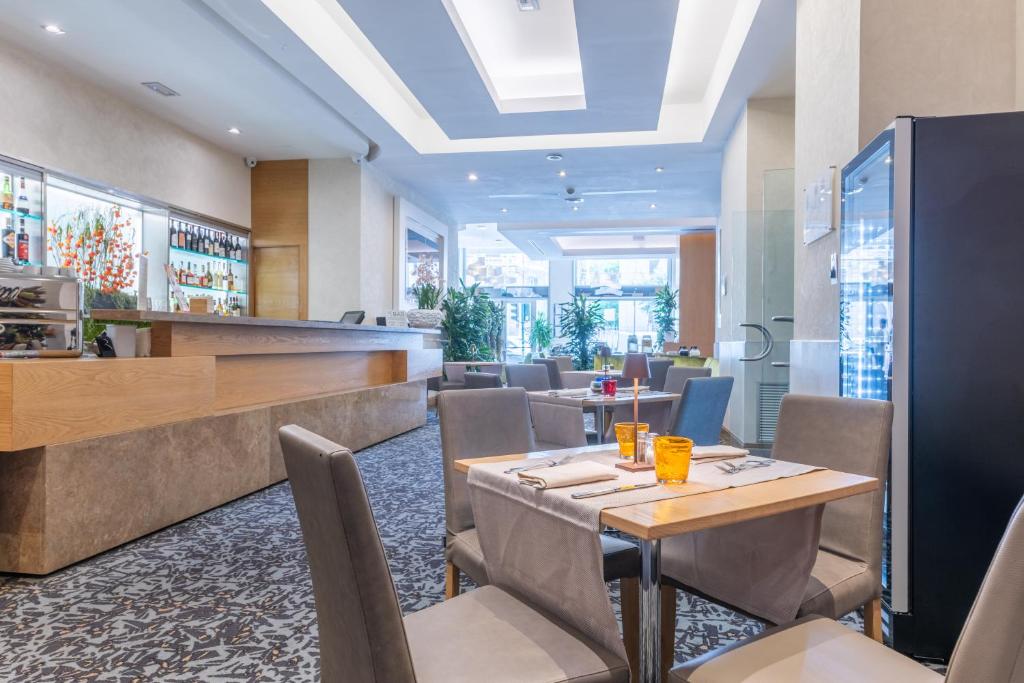 restauracja ze stołami i krzesłami oraz barem w obiekcie Best Western Hotel President - Colosseo w Rzymie
