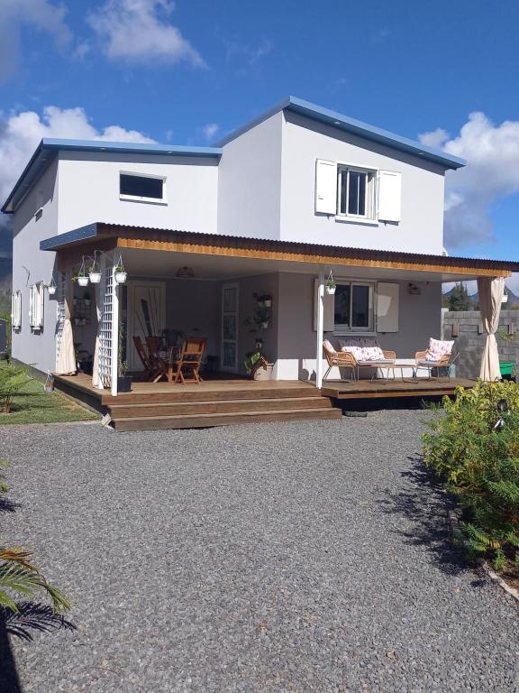 ein weißes Haus mit einer Veranda und einer Terrasse in der Unterkunft L'Etreinte des Cimes in Cilaos