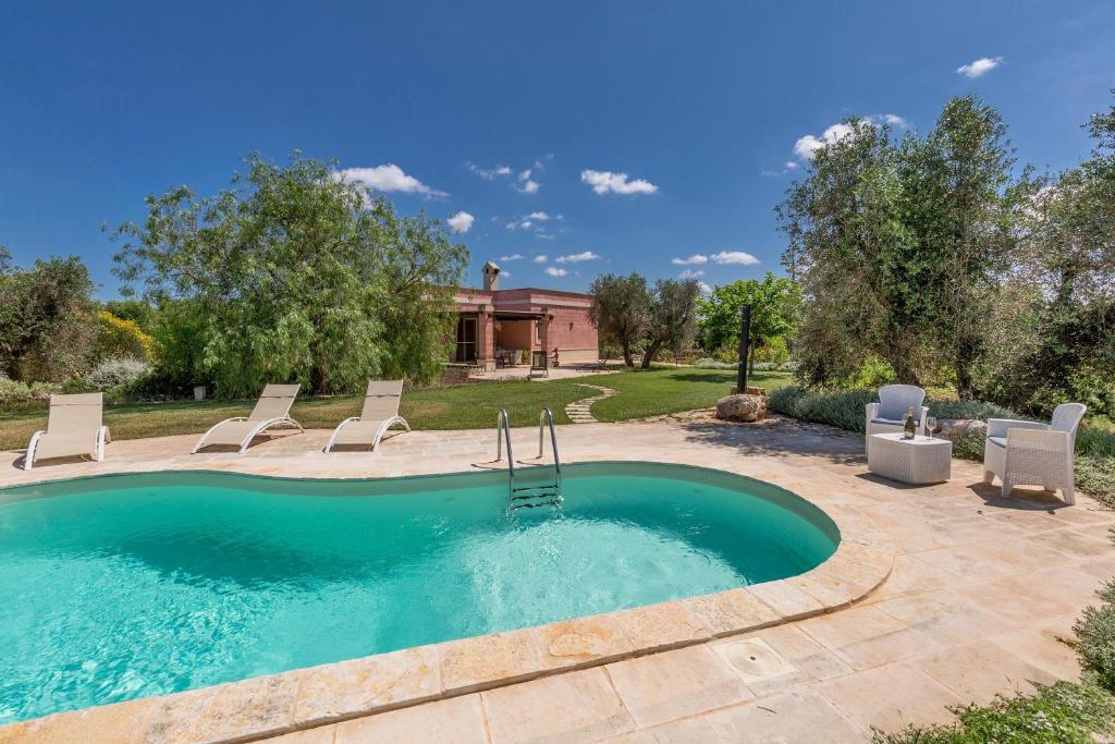 una piscina con sillas y una casa en Villa Le Majole by Perle di Puglia, en Manduria