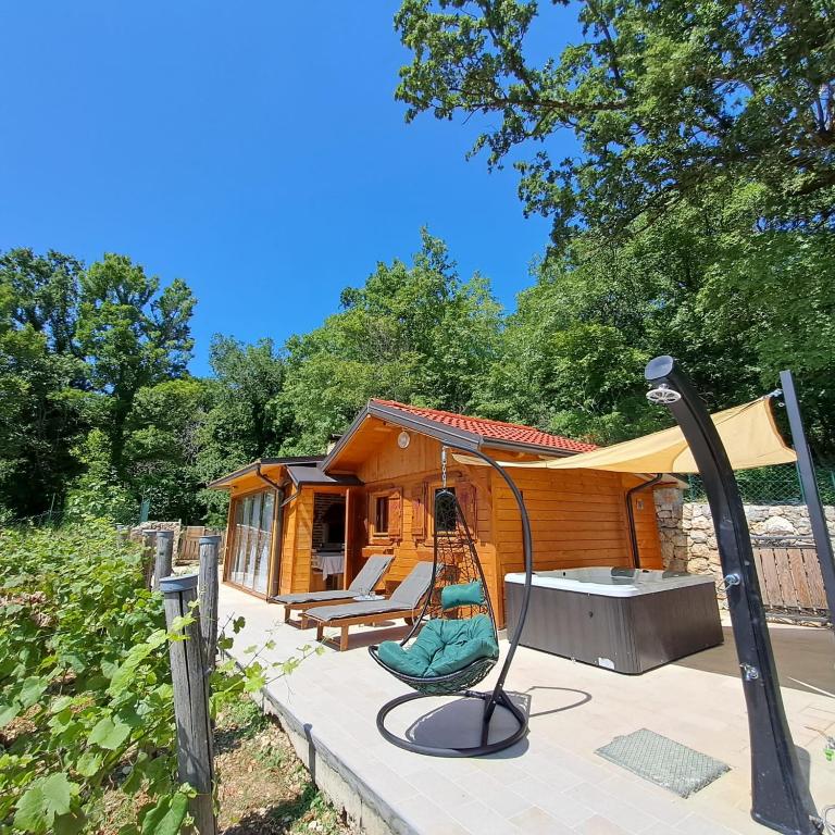 a tiny house with a swing and a porch at Vineyard house in Grižane