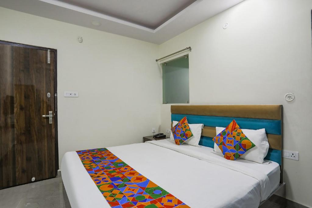 Un dormitorio con una cama con una manta de colores. en FabHotel SM Palace, en Chinhat