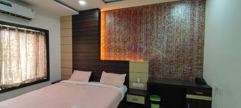 a bedroom with a bed and a large wall at HOTEL AL AMANA TOWER in Kondotti