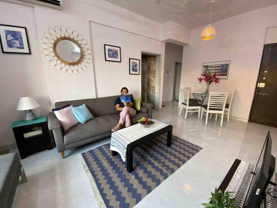 a woman sitting on a couch in a living room at Angel Views 201, Chapel Road, Bandra West by Connekt Homes in Mumbai