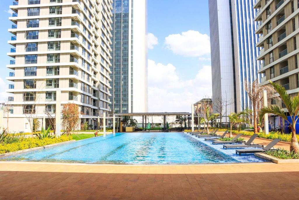 a swimming pool in the middle of two tall buildings at GTC Posh Hideaway in Westlands in Nairobi