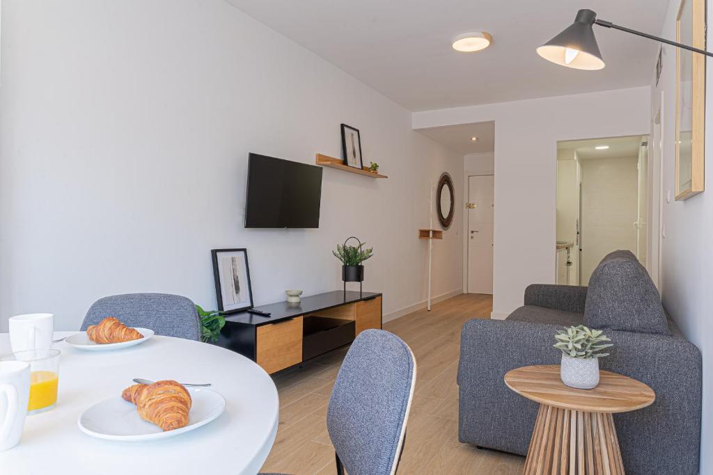 坎佩略Stay In Sunset Campello的客厅里有一张白色的桌子和椅子