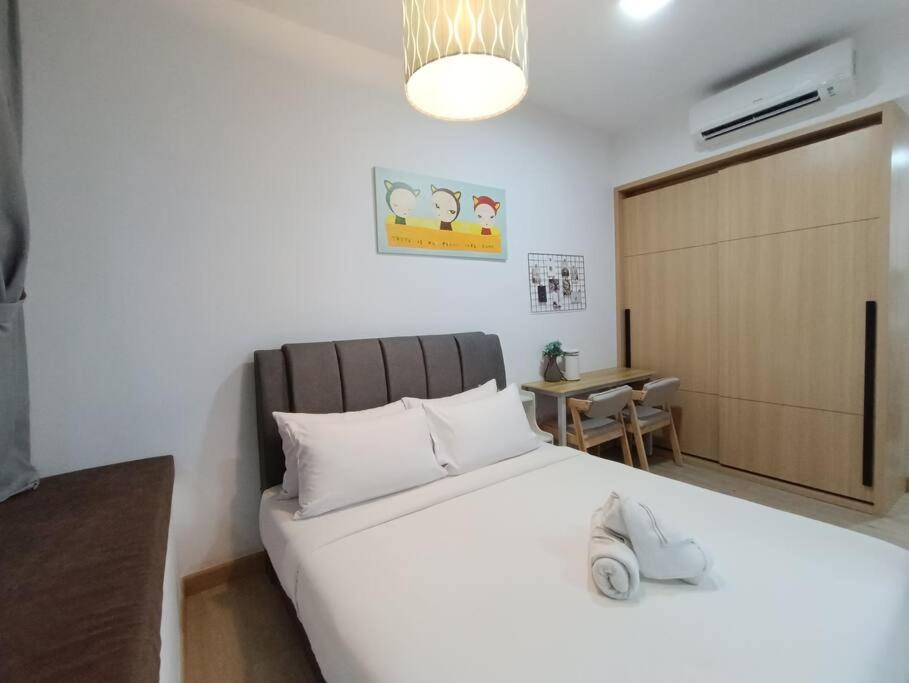 a bedroom with a large white bed and a table at CL 93B Balcony KLCC View Studio in Kuala Lumpur