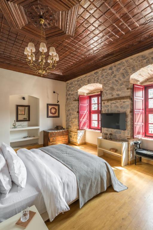 una camera da letto con un letto grande e una TV di FOS Hydra residence a Hydra