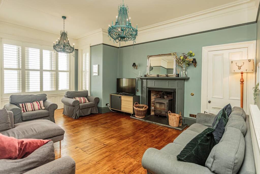 a living room with two couches and a fireplace at Southcliff House in Portpatrick