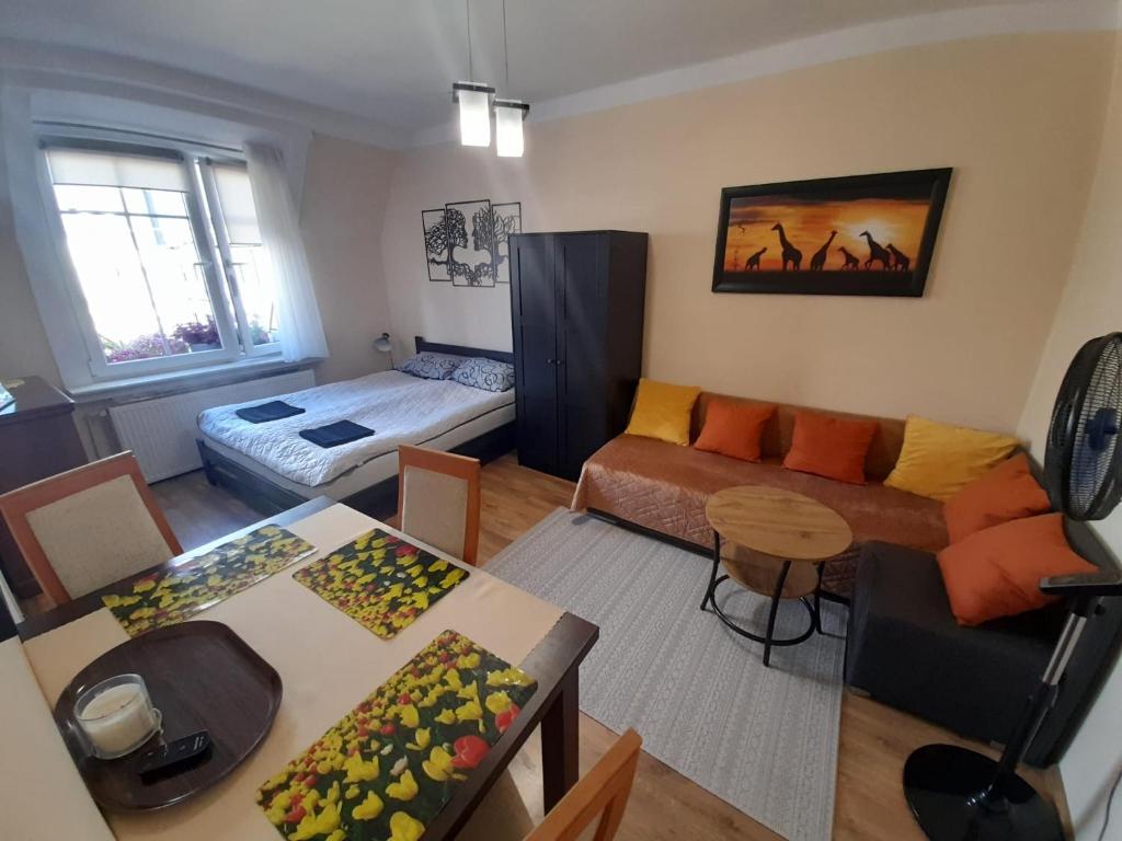 uma sala de estar com um sofá e uma mesa em Apartament Garbary em Poznań