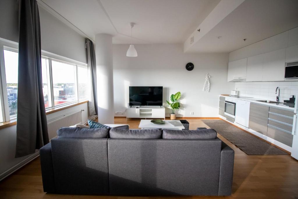 a living room with a couch and a kitchen at Flexi Homes Itäkeskus in Helsinki