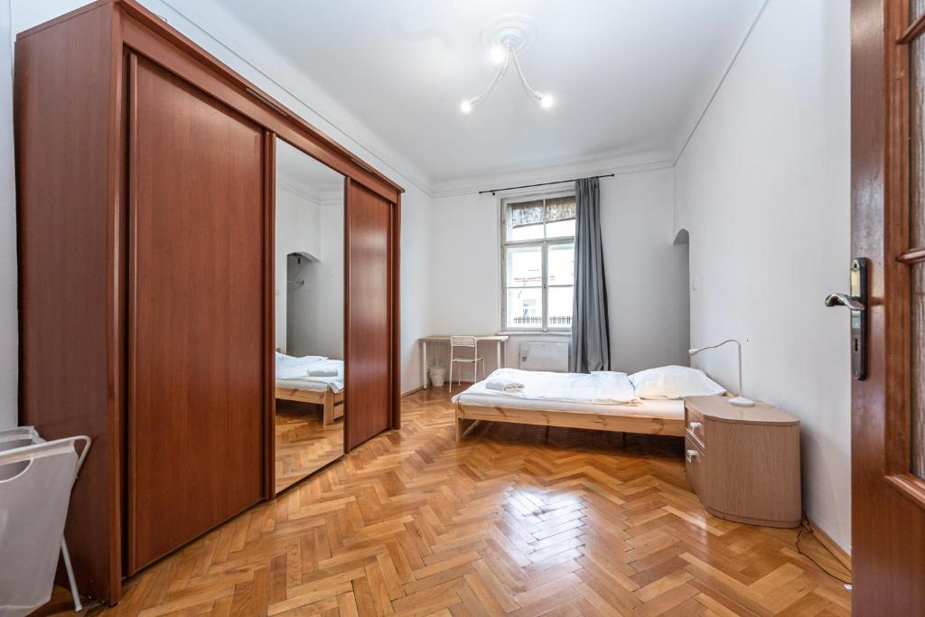 - une chambre avec un lit et un grand miroir dans l'établissement Jaromirova 9, à Prague