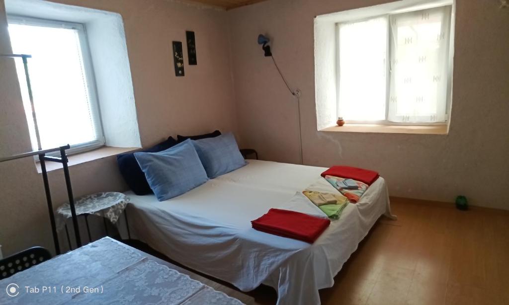 a small bed in a room with two windows at Granichar 2 Boards in Granichar