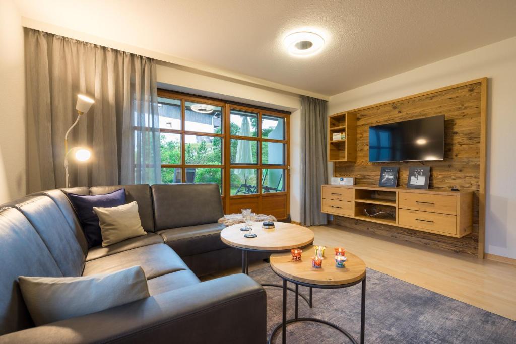 a living room with a couch and a tv at Ferienwohnung Alpentraum-Panorama Chalet in Oberstdorf