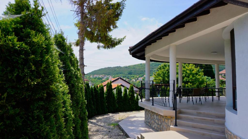 una veranda di una casa con tavolo e sedie di вила Ема Балчик - villa Ema Balchik a Balchik