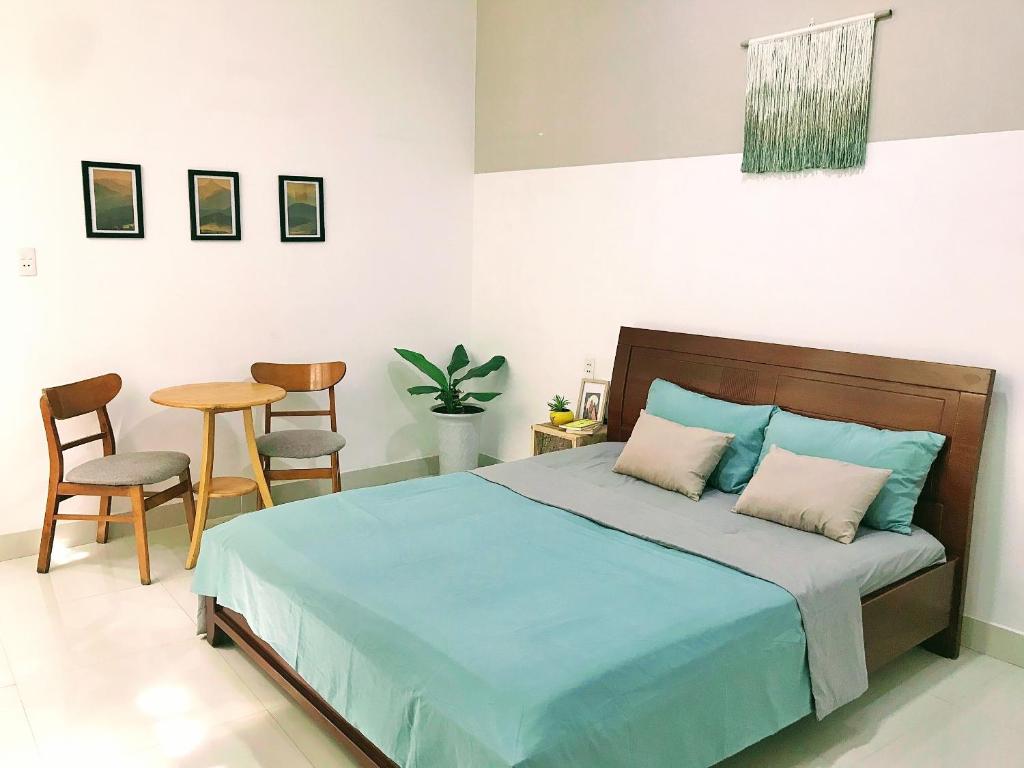 1 dormitorio con 1 cama, mesa y sillas en Nạp Homestay, en Kinh Dinh