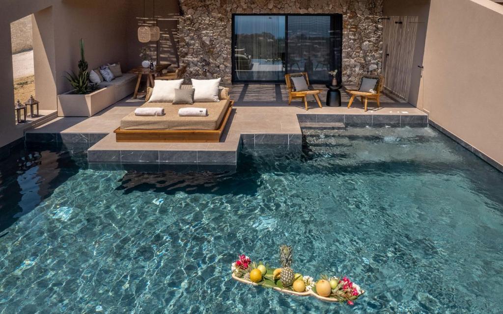 a swimming pool with two bowls of fruit in it at Memorias Villas and Suites in Vasilikos