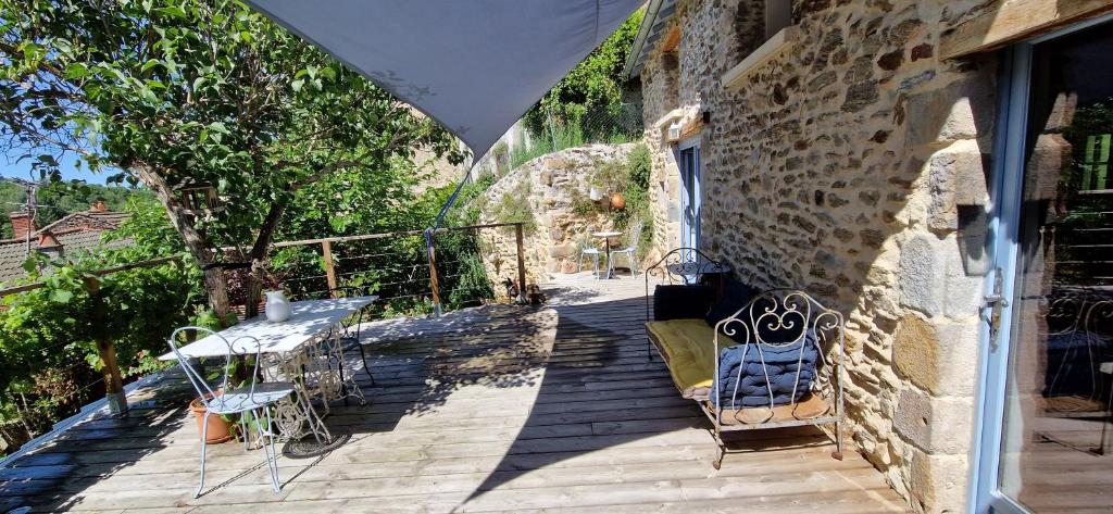 a balcony with a table and chairs on a building at La maison du vigneron in Auzon