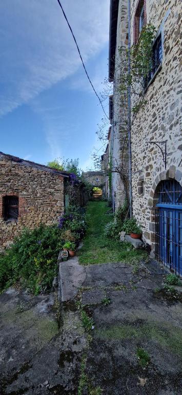 an old brick building with a gate in a yard at La maison du vigneron in Auzon