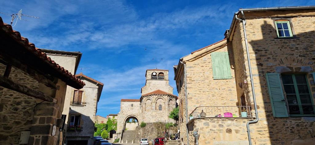 an old building with a clock tower in a street at La maison du vigneron in Auzon